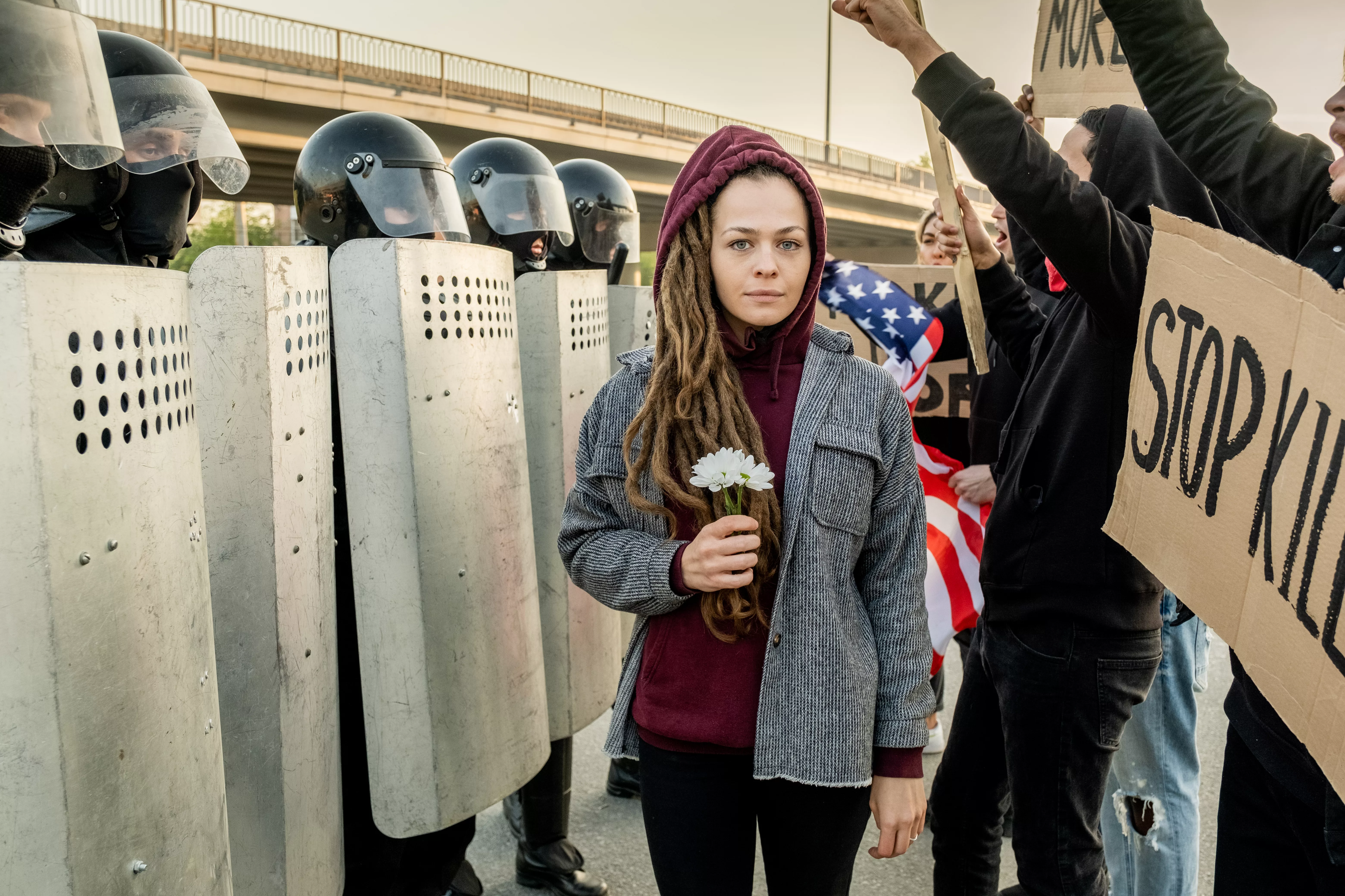 woman-between-displeased-crowd-and-riot-police