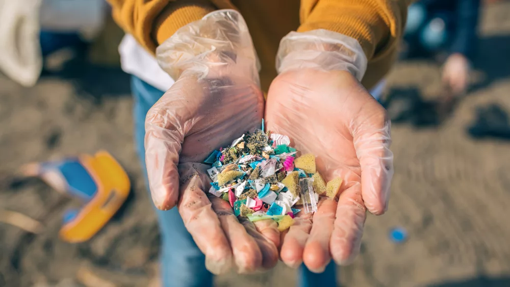 hands-with-microplastics-on-the-beach
