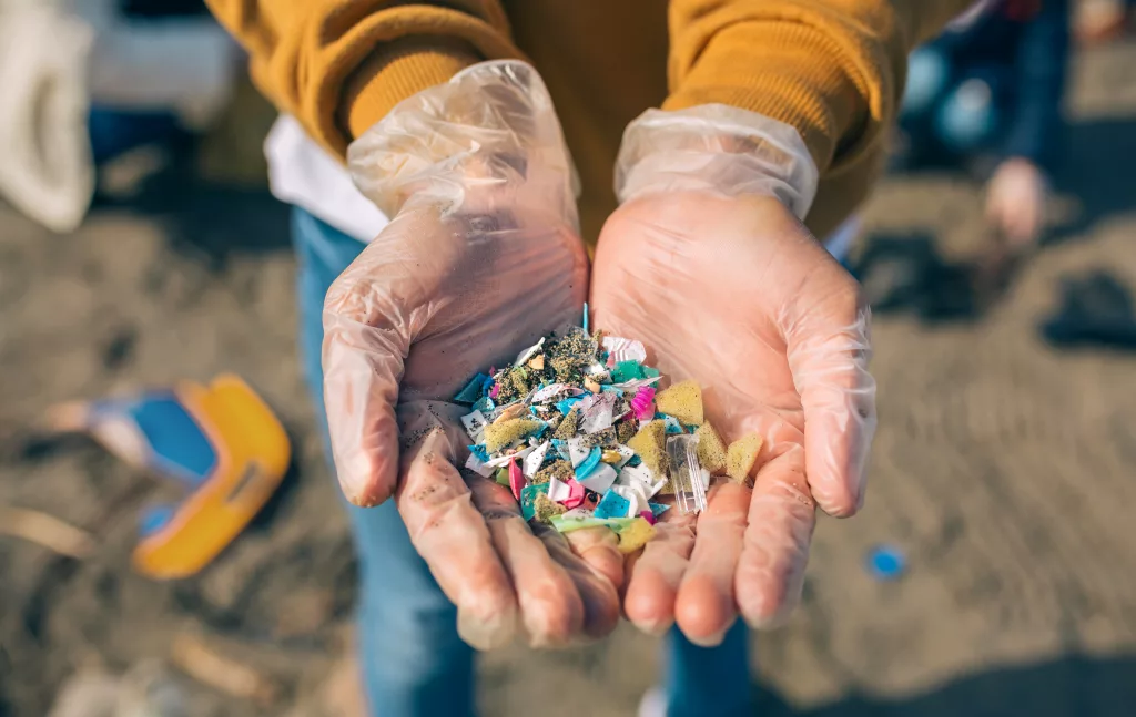 hands-with-microplastics-on-the-beach
