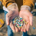 hands-with-microplastics-on-the-beach