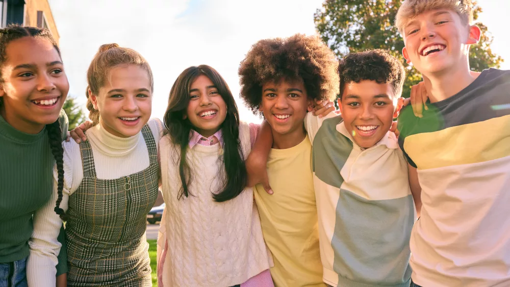 portrait-showing-class-of-secondary-or-high-school-pupils-standing-outside-school-building-hugging