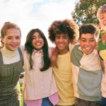 portrait-showing-class-of-secondary-or-high-school-pupils-standing-outside-school-building-hugging