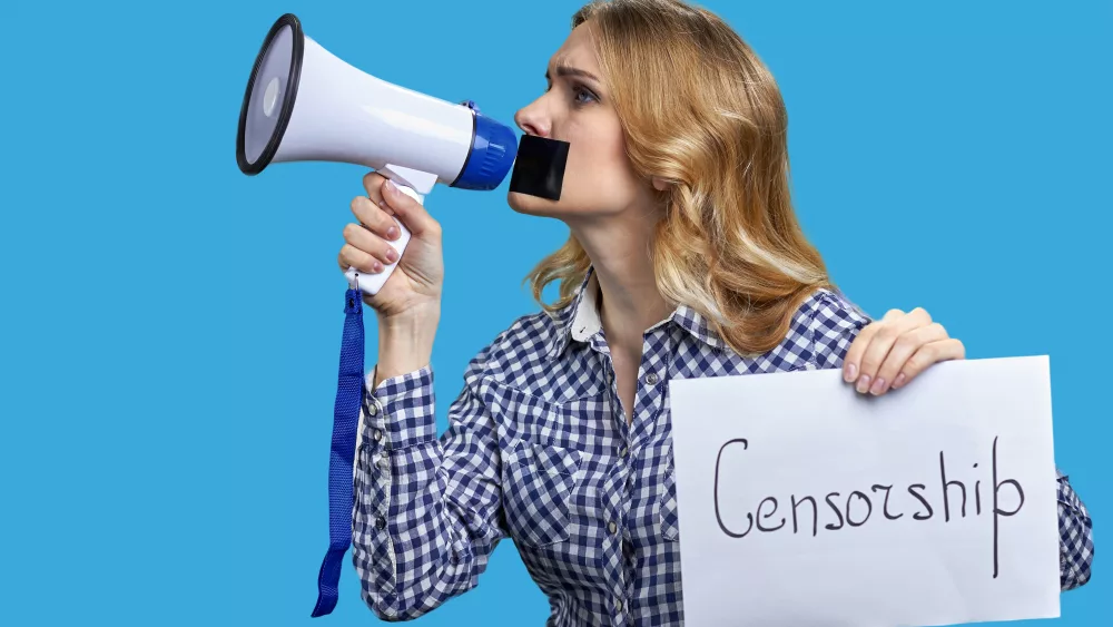 young-blonde-woman-holding-megaphone-and-banner-with-censorship-inscription