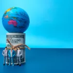 banknotes-globe-and-miniature-people-on-a-blue-bac-2024-12-08-00-12-19-utc