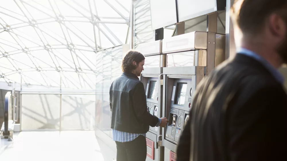 rear-view-of-businessmen-buying-railway-tickets