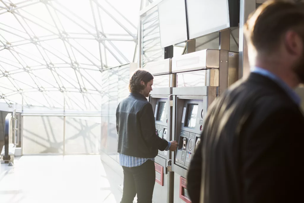 rear-view-of-businessmen-buying-railway-tickets