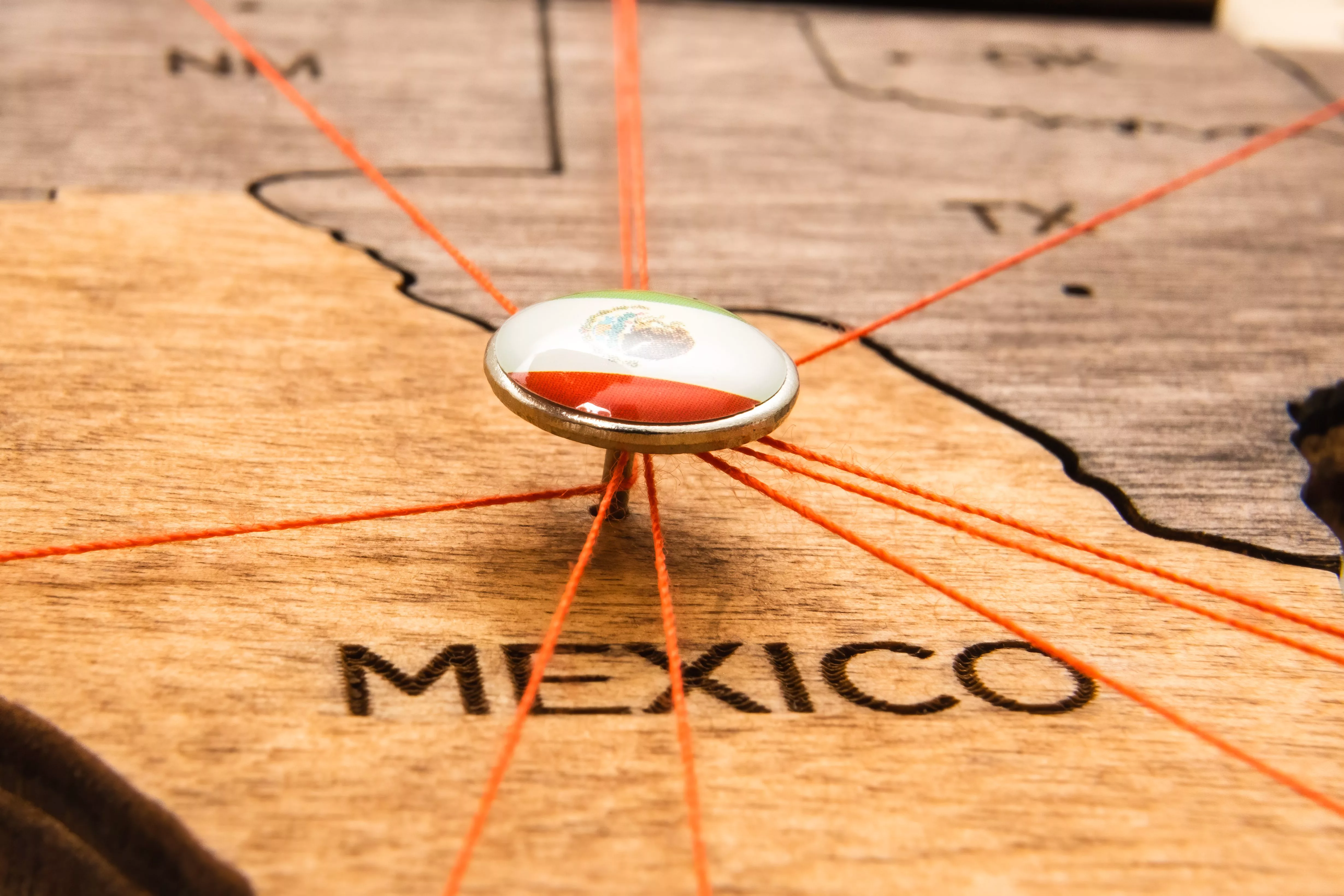 mexico-flag-on-the-pushpin-and-red-threads-on-the-wooden-map