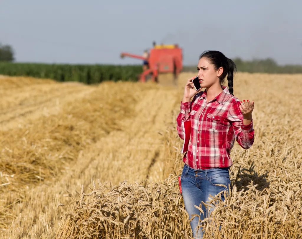 Woman standing in field talking on cell phone.