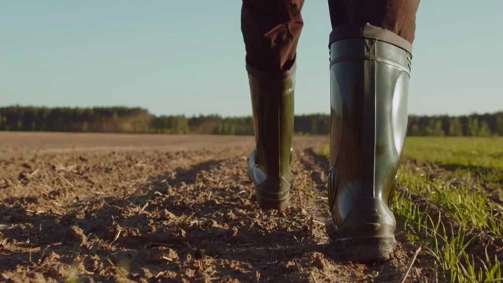 farmer-boots-through-plowed-farm-field