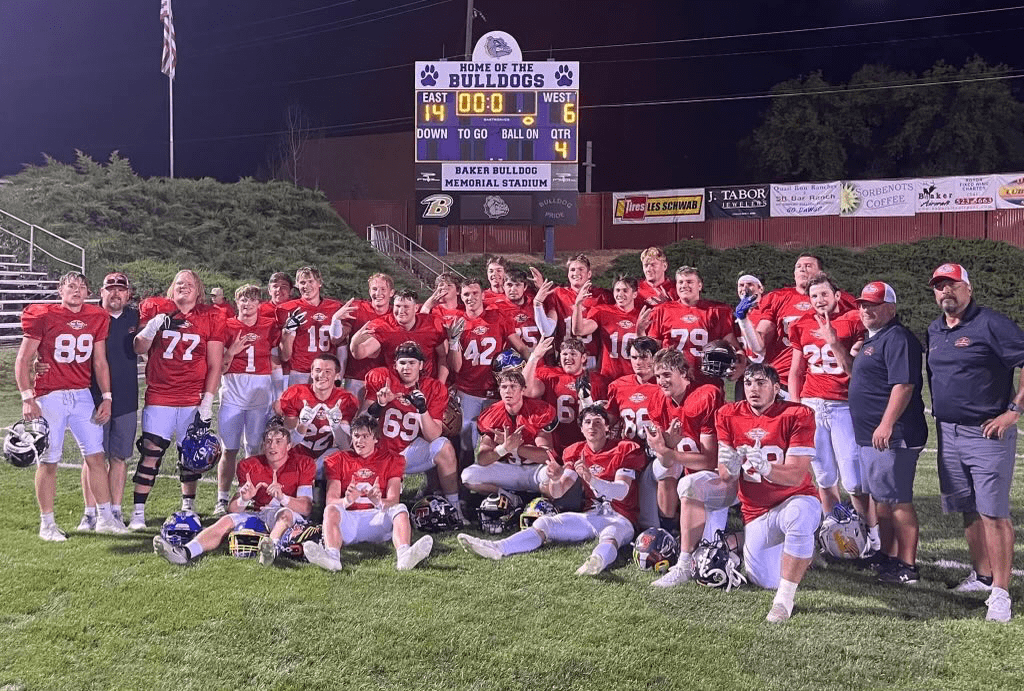The East Team poses in front of the scoreboard after their Shrine Game win