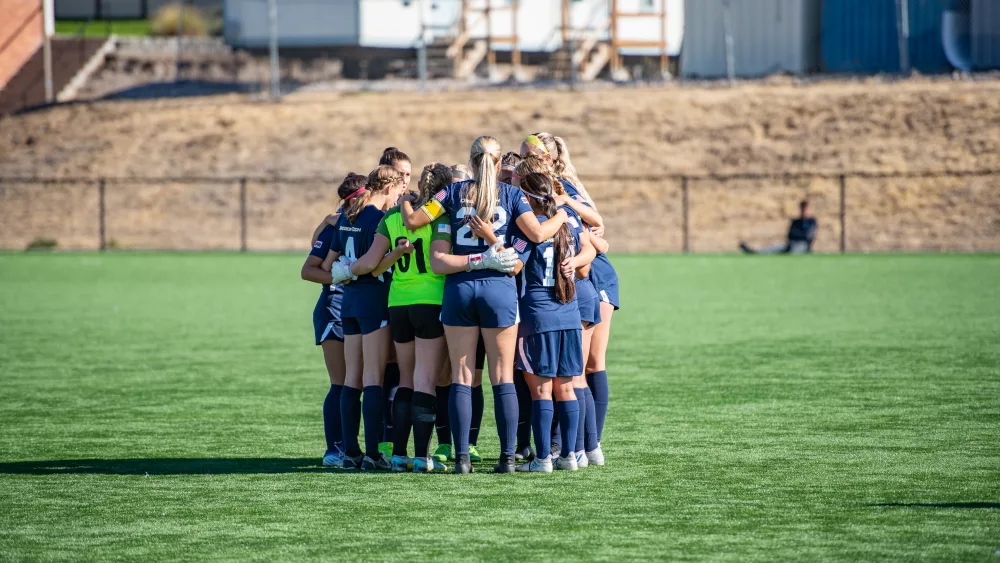 The Oregon Tech women's soccer team huddling before a match