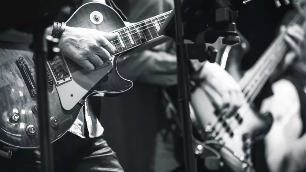Rock and roll music background^ guitar players on a stage^ monochrome photo with selective focus