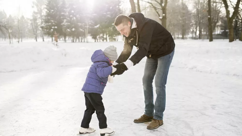father-and-daughter-ice-skating-on-frozen-lake-HAPF02110