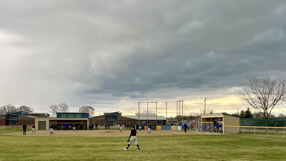 Henley softball vs Mazama with dark clouds over the field