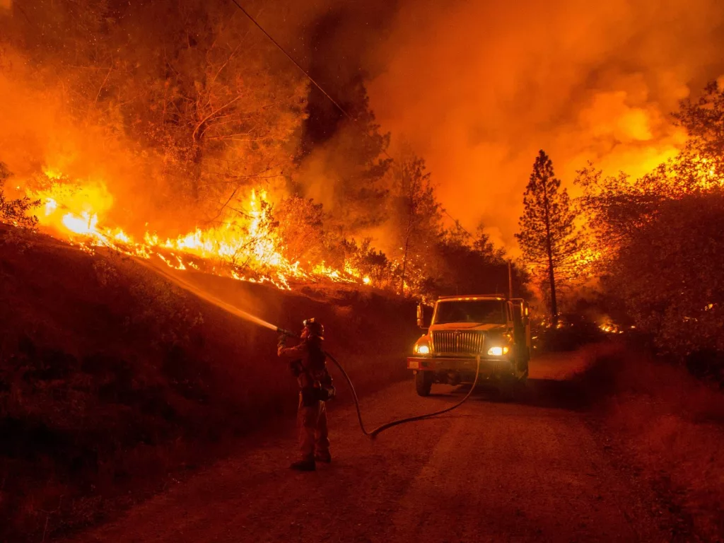 A firefighter spraying a wildfire