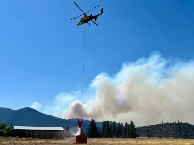 A helicopter picking up water to dump on the Shelly Fire