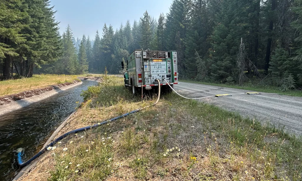 Engine 334 drafting water out of a waterway near the Lemolo fire to pump water up to the fireline