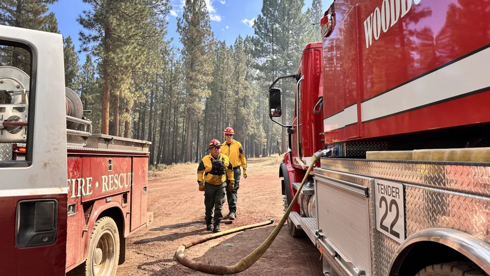 Firefighters stand near trucks on the Copperfield Fire