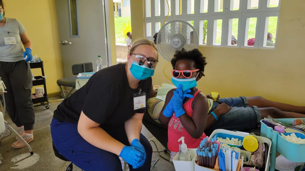 An OIT dental student with a child in Grenada