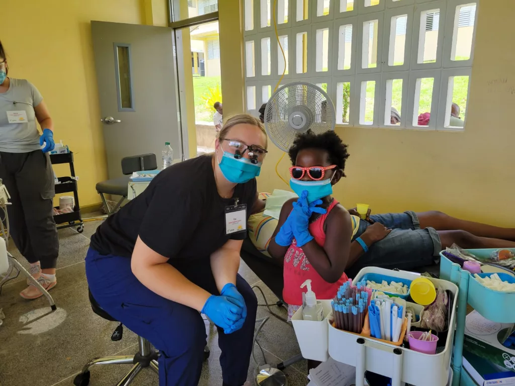 An OIT dental student with a child in Grenada