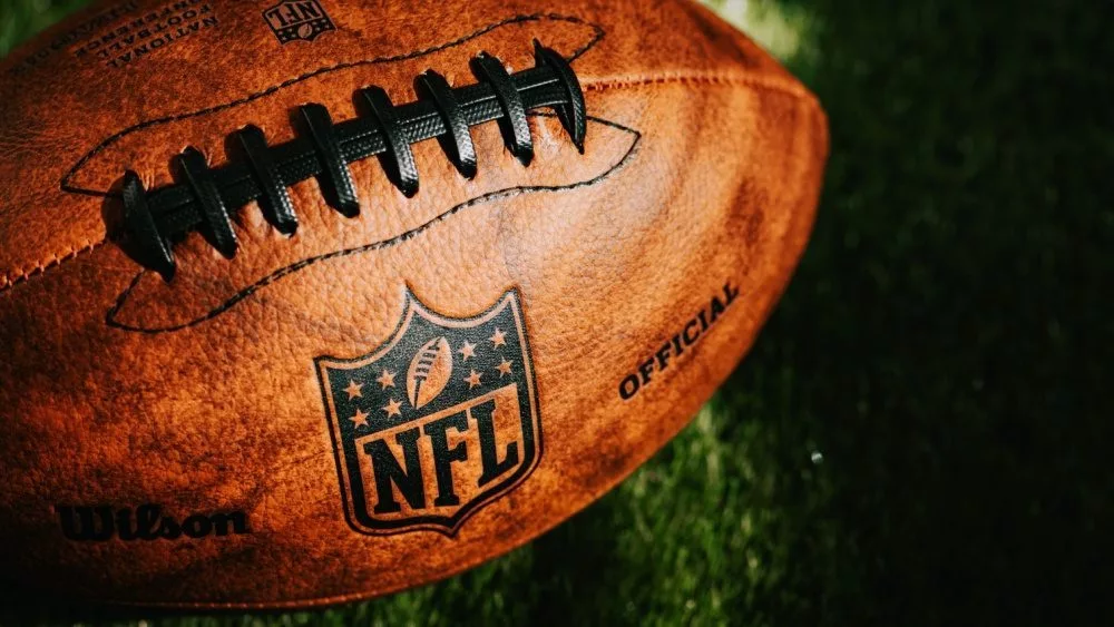 NFL background photo. Ball placed on green grass in beautiful light. NEW YORK^ USA^ SEPTEMBER 11^ 2023