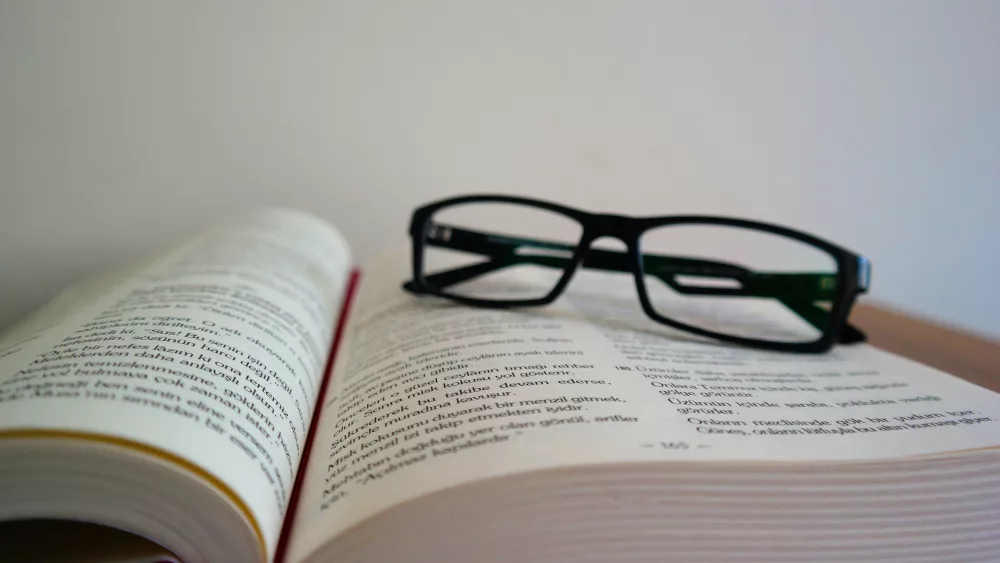 A pair of reading glasses sitting on an open book