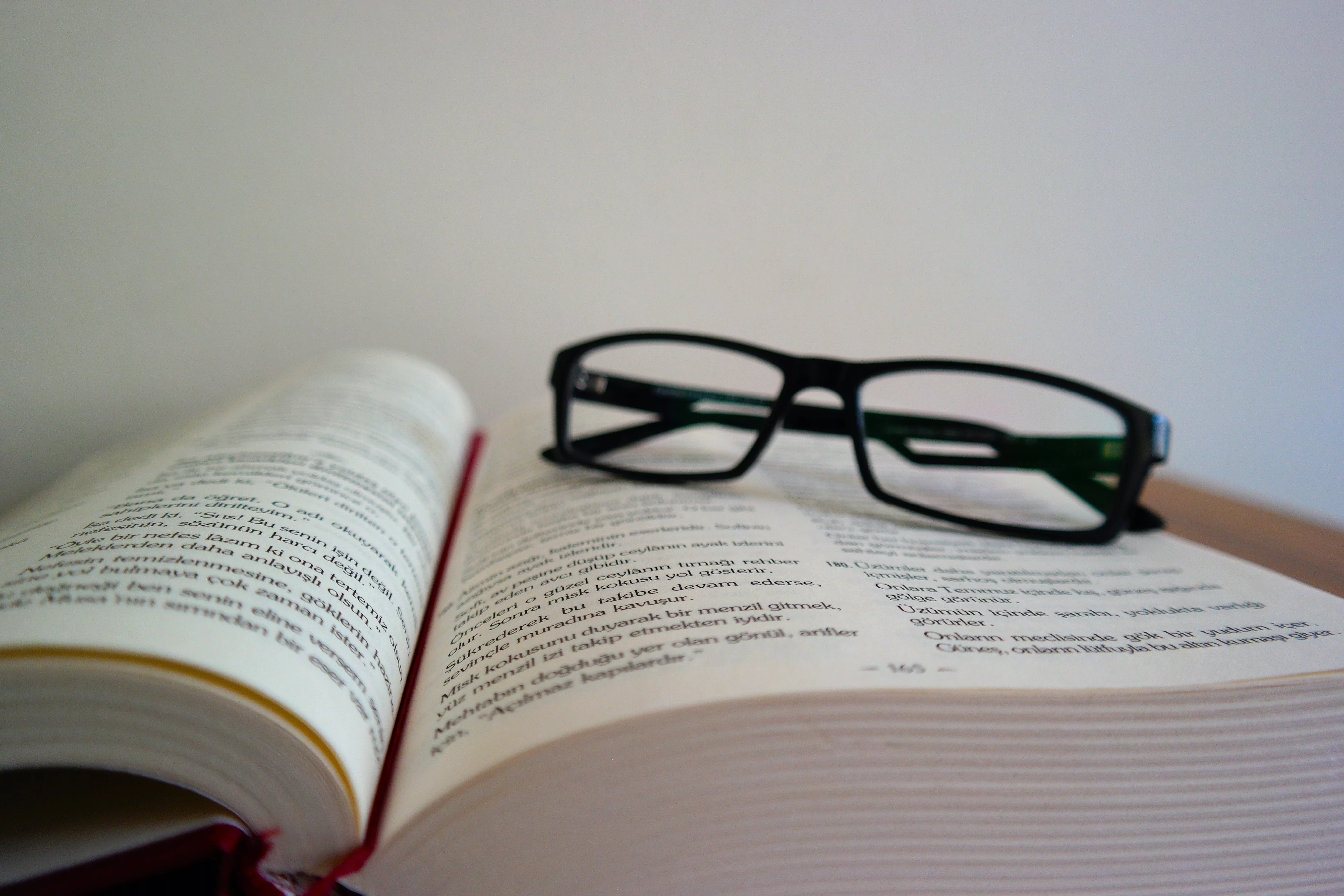 A pair of reading glasses sitting on an open book