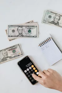 Cash, notepad, and calculator for budgeting