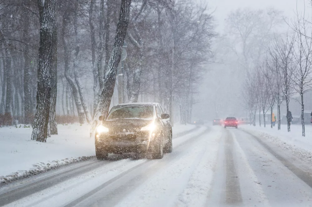 carsmovingonslipperysnowyroadatcitystreetduring