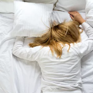 awomancoversherfacewithapillow-thewoman