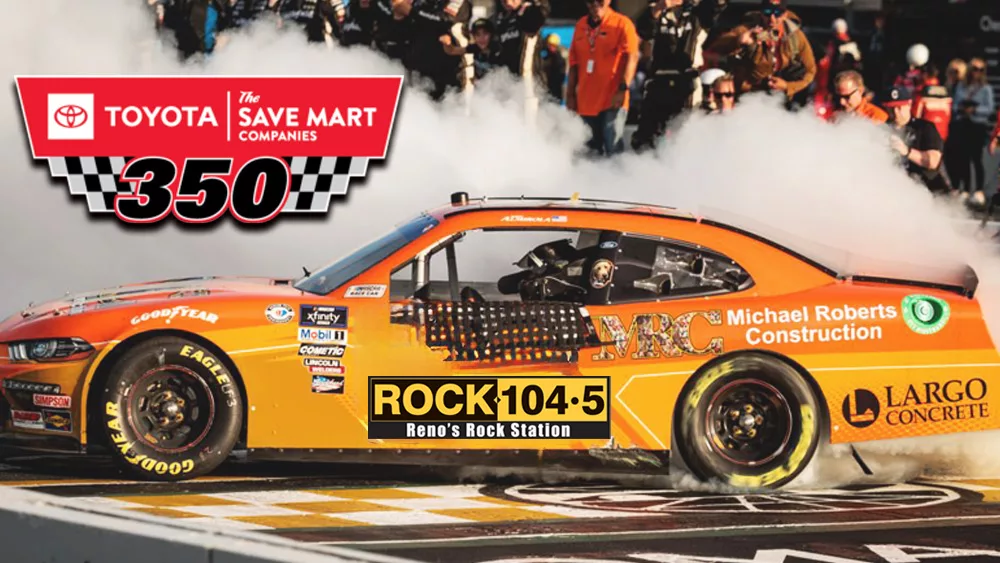 Orange Race car with the Rock 104.5 logo burning out on the racetrack.