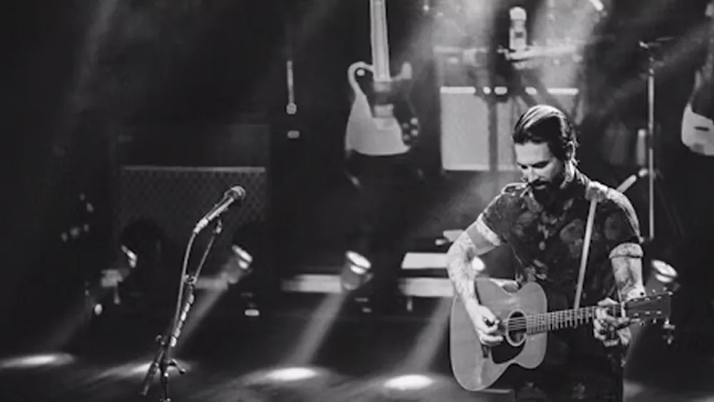 Dashboard Confessionals Black & White pic of lead on stage with guitar