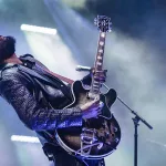 Gary Clark Jr on stage with a guitar.