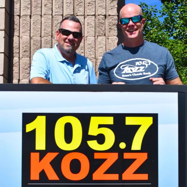 Kevin & Jay standing by sign with KOZZ logo