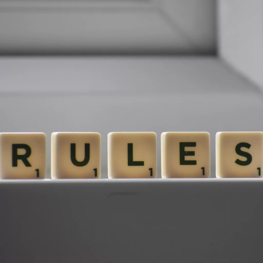image with rules spelled out with individual dominoes with letters on them.