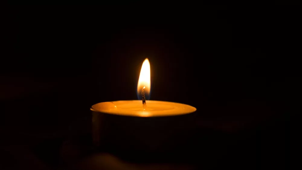 Lit memorial candles in the dark^ burning candles