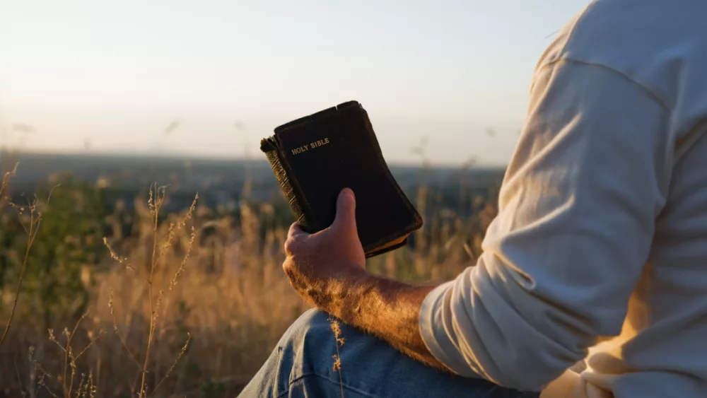 30064-man-holding-bible-gettyimages-redgoldwing_source_file487099