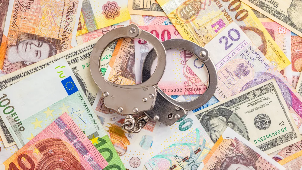 handcuffs-on-various-banknotes-background-top-view-2