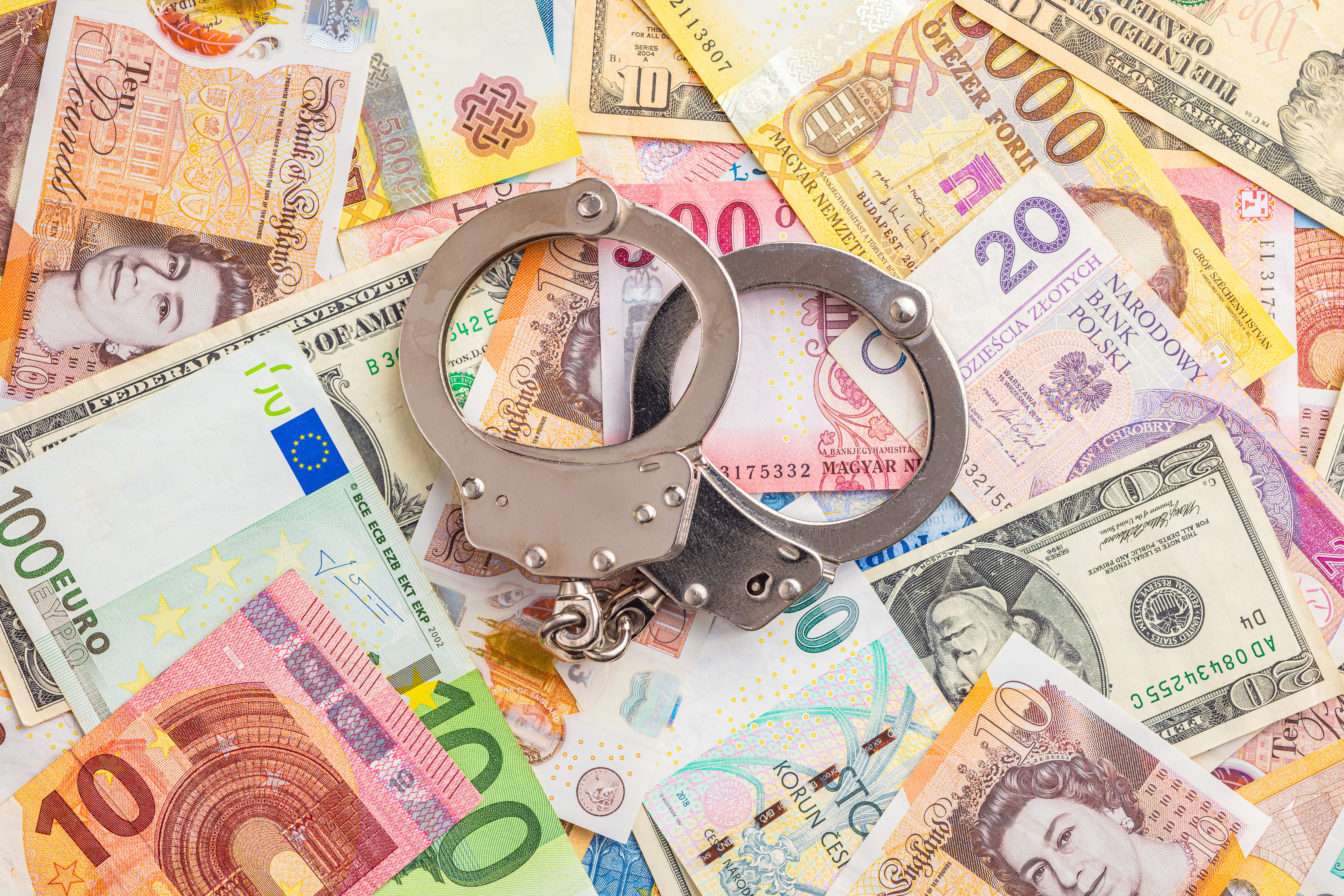 handcuffs-on-various-banknotes-background-top-view-2