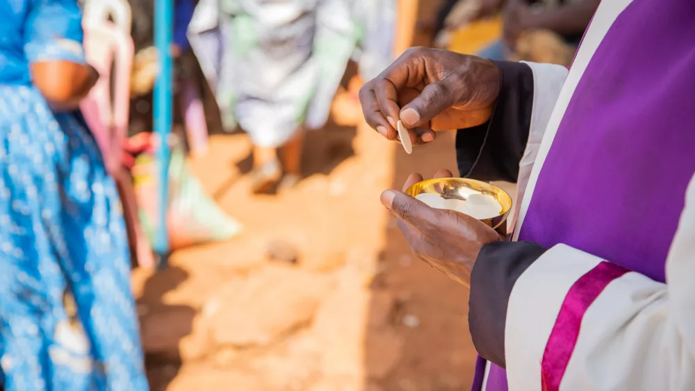 close-up-of-the-hands-of-an-african-priest-who-is-about-to-give-the-sacramental-bread-to-believers