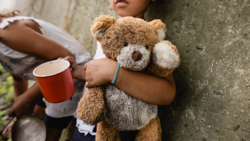 cropped-view-of-homeless-african-american-children-with-dirty-teddy-bear-begging-alms-in-slum