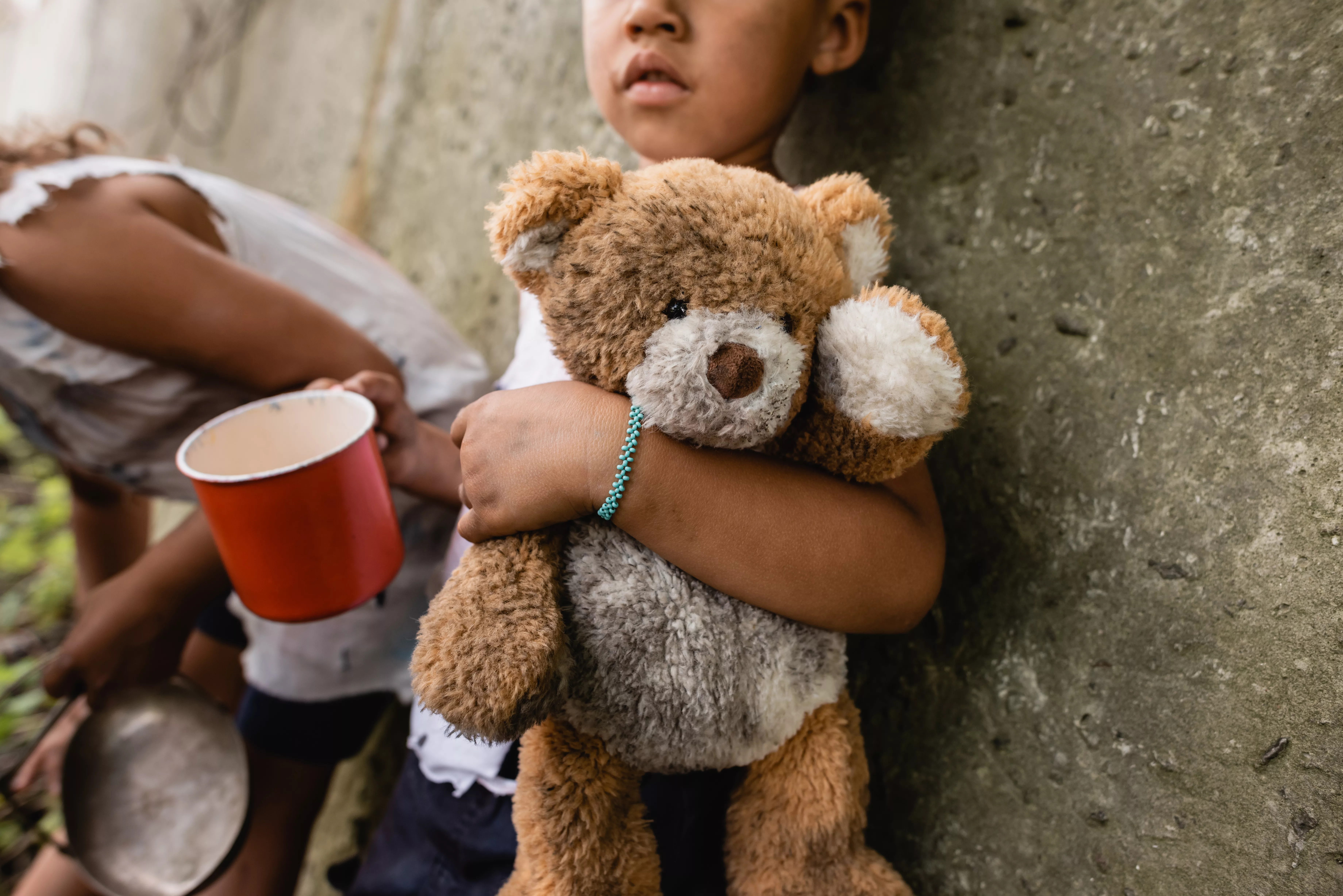 cropped-view-of-homeless-african-american-children-with-dirty-teddy-bear-begging-alms-in-slum