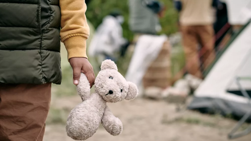 hand-of-homeless-child-holding-white-teddybear