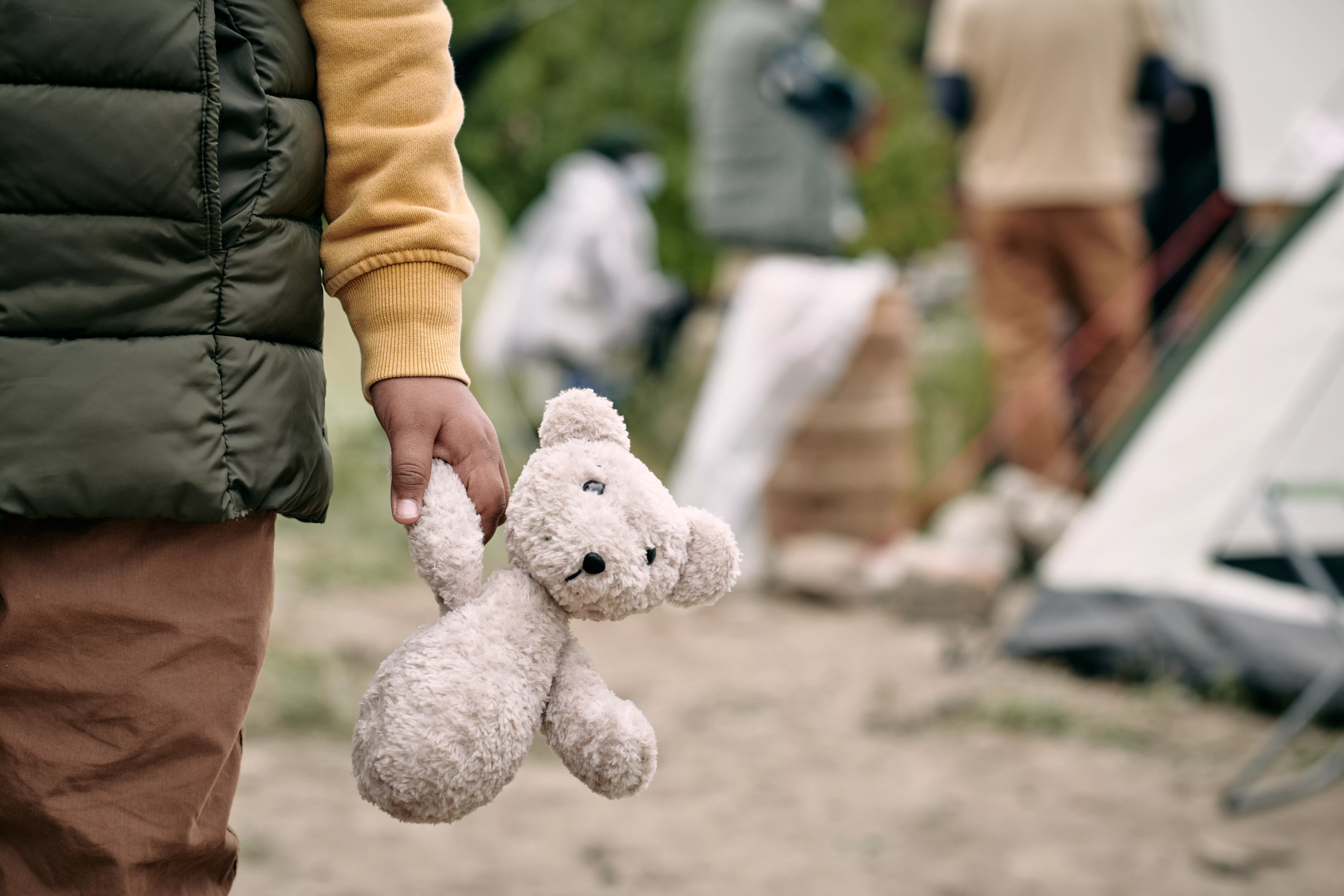 hand-of-homeless-child-holding-white-teddybear