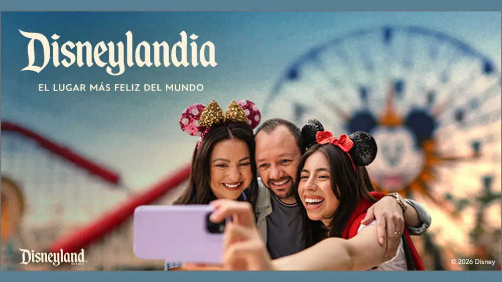 Promotional graphic for a Disneyland Resort giveaway. A smiling family of three wearing Mickey and Minnie ears takes a selfie in front of a colorful Disneyland background with a Ferris wheel. Spanish headline reads, “Podrías ganar una visita a Disneylandia de parte de KXYZ.” Below, Spanish text explains the chance to win a family trip to Disneyland Resort, encouraging listeners of La Caliente 92.1 to visit the website and listen for a cue to register. Disneyland logo and legal disclaimer text appear at the bottom.
