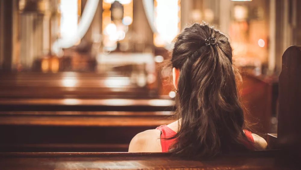 21950-woman-in-church-pew-gettyimages-kadirdemir357987