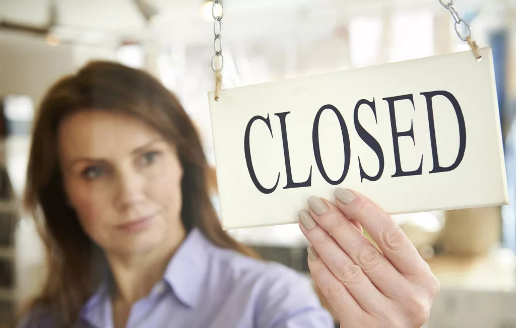 store-owner-turning-closed-sign-in-shop-doorway-6