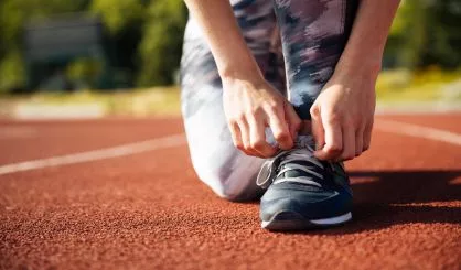 closeup-portrait-of-a-young-woman-tying-sneakers