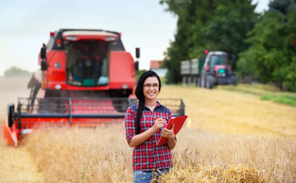 farmer-girl-on-field-with-combine-harvester