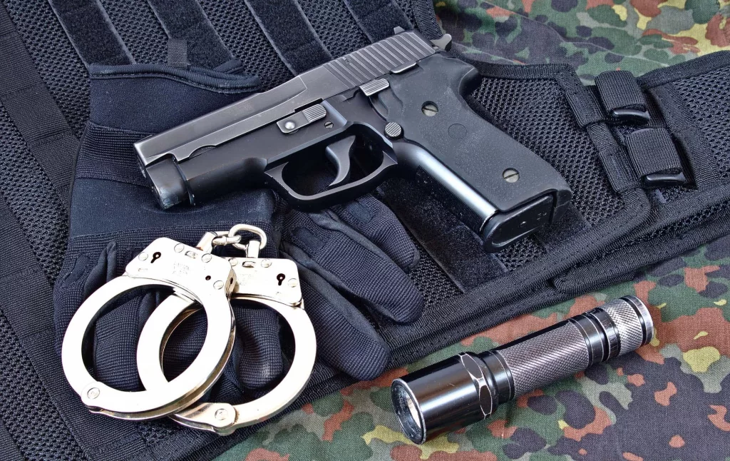 handgun-with-handcuffs-gloves-and-flashlight-on-tactical-vest-a